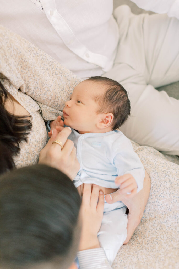 mom holding newborn son on couch