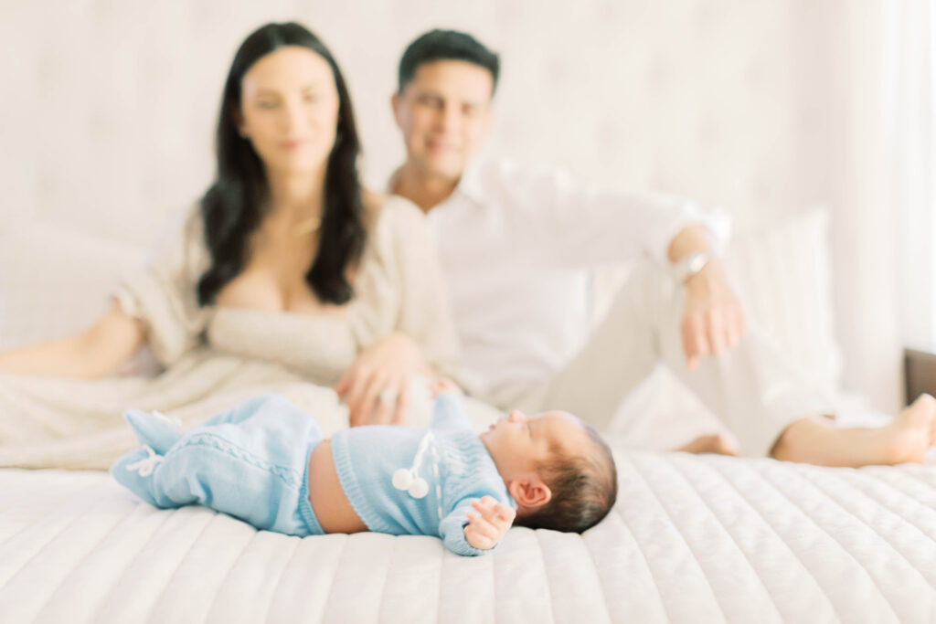 mom and dad on bed with newborn baby boy