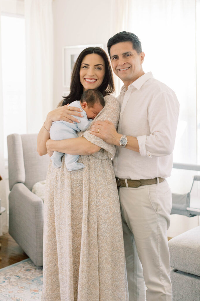 mom and dad holding newborn boy in their home