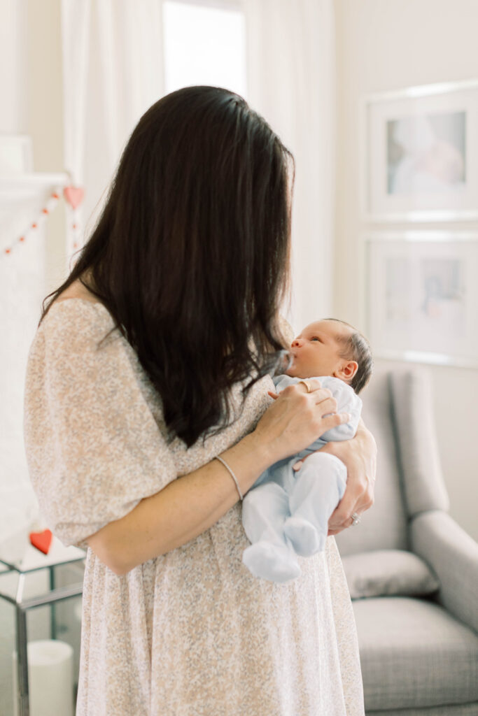 mom holding newborn son in her home