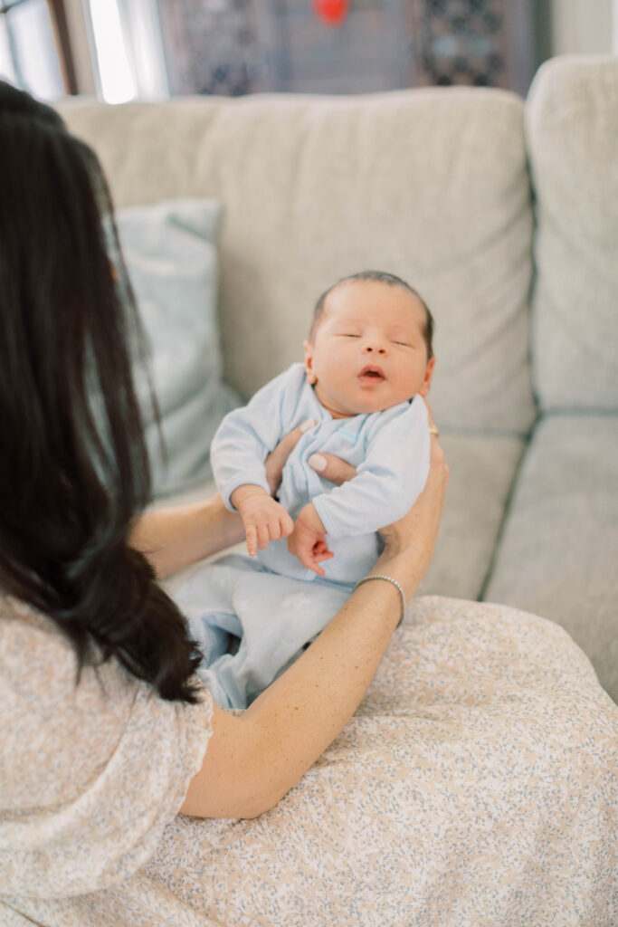 mom holding newborn son in her home