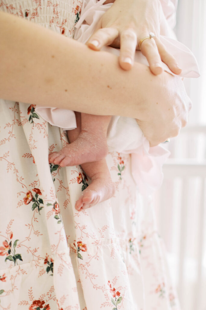 Mom in a floral dress holding newborn