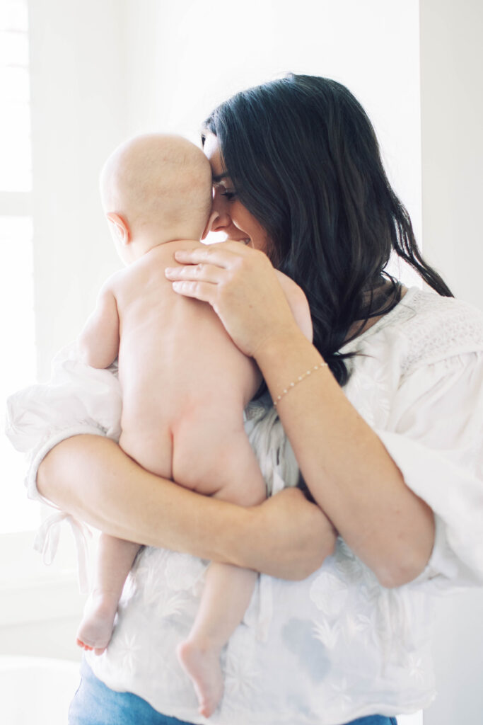 mom snuggling baby after bath 