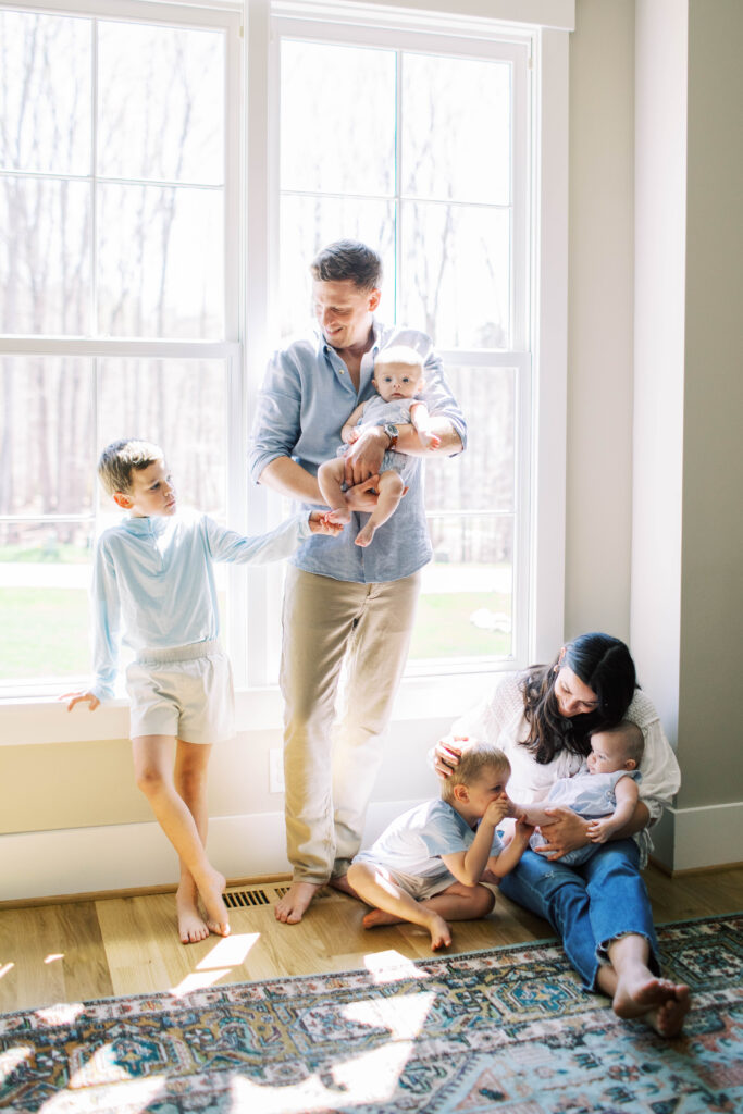 family snuggled up together by window with 4 boy kids